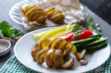 Homemade Tornado spiral baked potato with vegetable salad. Tomatoes cucumber pepper