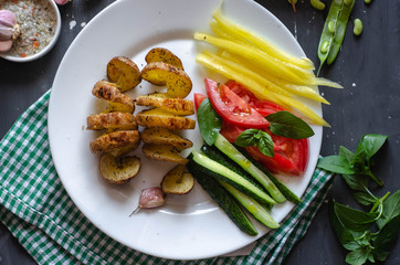 Homemade Tornado spiral baked potato with vegetable salad. Tomatoes cucumber pepper