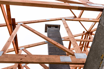 System chimney on a detached house under construction, visible chimney block and elements of roof trusses.