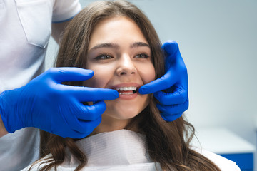 beautiful young brunette woman having examination at dental office while dentist showing whitening results to happy patient - obrazy, fototapety, plakaty