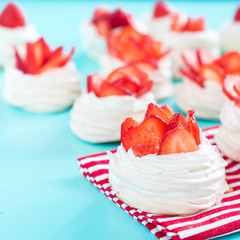 Beautiful pavlova cakes with strawberries on a blue background. Selective focus. Tasty sweet breackfast. Wedding morning. Meringue with cream.