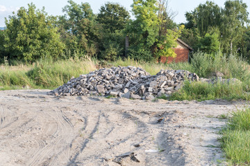 Fototapeta premium Pig pile of tarmac or asphalt road parts cracked and demolished dumped on the sandy field after replacement of old street 