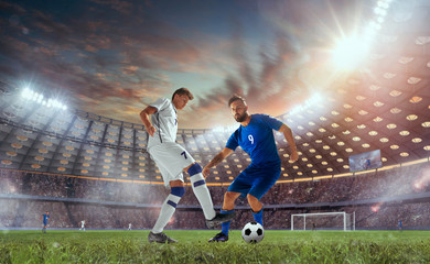 Naklejka premium Soccer players in action on professional stadium on sunset.