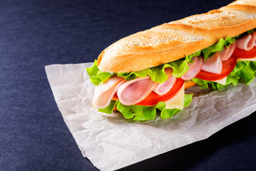 Big submarine sandwich with ham, cheese and salad