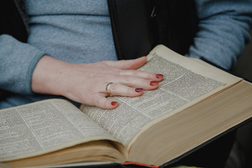 Woman hand is on open thick book