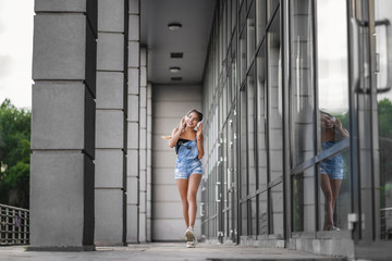 Photo of attractive young teenage girl walking with cellphone and earphones