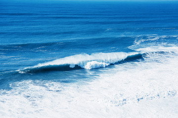 Fototapeta premium View of the blue sea or ocean with foam and waves background.