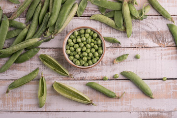 fresh raw peas on a wooden table