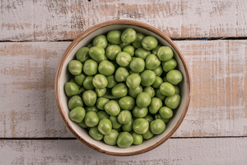 fresh and raw pea seeds on a wooden table