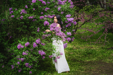 Woman in front of blooming bush. Blossom of lilac.