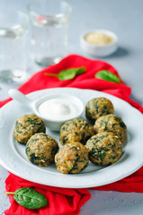 Cheese spinach balls with spinach leaves and greek yogurt sauce