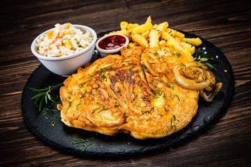 Fried pork chop, French fries and vegetable salad