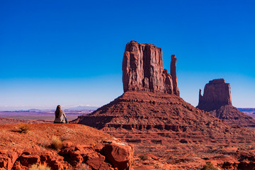 Woman seating in a Blue Sky day in Monument Valley, Arizona 