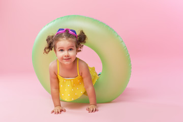 Obraz na płótnie Canvas Portrait of happy little girl with neon inflatable rubber circle having fun isolated on pink background