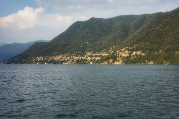 iew from the water of Lake Como in the rays of the setting sun.