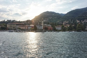 iew from the water of Lake Como in the rays of the setting sun.