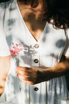Detail of the hands of a firl holding some flowers