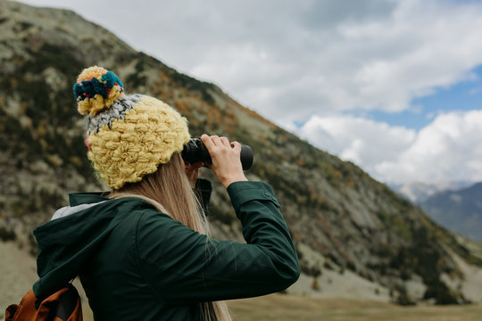 woman with binoculars in the mountains