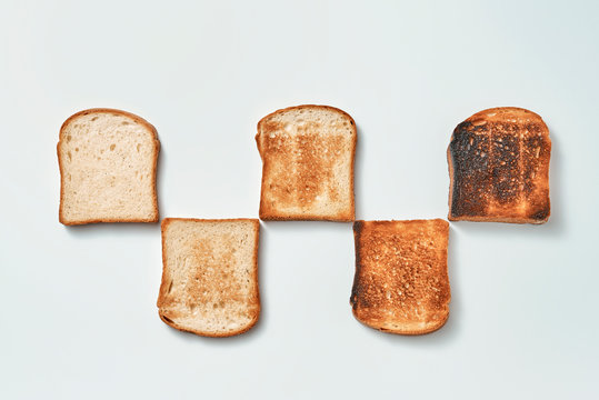 Pattern of pieces of toasted, toasted bread on a gray background with copy space. Flat lay