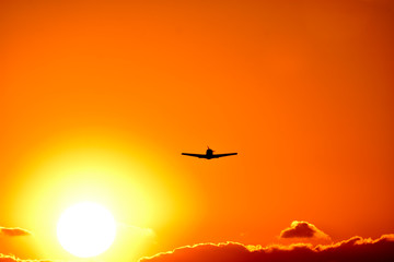 Fototapeta na wymiar 美しい夕焼け雲の空・夕日を背景に飛行する航空機・セスナ機(シルエット)景色 撮影場所：日本(秋) 「九州・熊本県」Beautiful sunset Cloud sky, aircraft flying against the backdrop of the setting sun, Cessna aircraft (silhouette) scenery Location: Japan