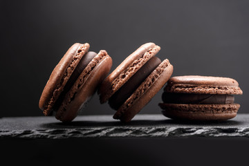 Three macaroons close up on stone dish on black