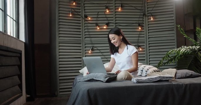 Young panasian girl having a video chat with her friends via internet. Student talking to her parents using laptop. pretty woman chatting with her boyfriend - communication concept 4k
