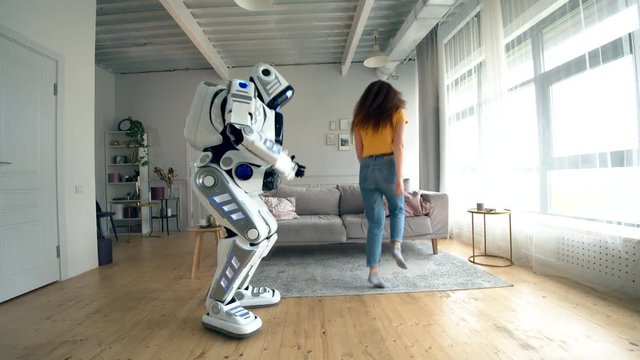 Human-like robot and a woman are dancing and jumping