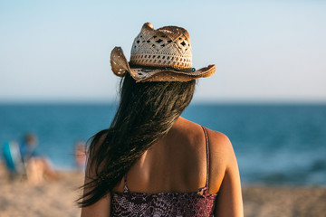 Woman on the beach looking at the sea