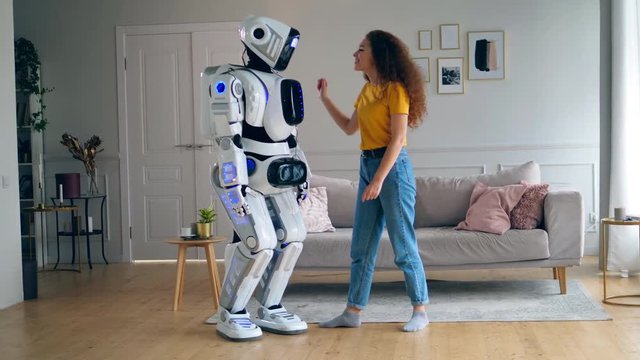 A cyborg is dancing after getting hugged by a lady