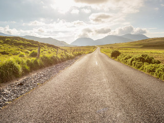 Small country road into mountains, Selective focus, Cloudy sky. Travel concept.
