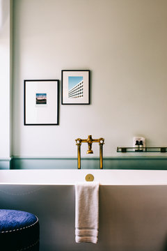 Beautiful Deluxe Bathroom Detail With Framed Photographs Above Bathtub