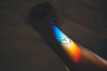 Arm on a bed with light on a heart tattoo