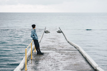 Stylish female standing on wet pier