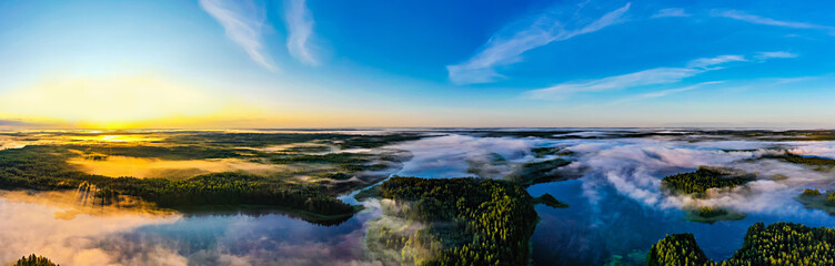 Sun rises on horizon, panoramic landscape. Beautiful morning in green forest near lakes. Environment concept