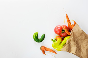 Ugly vegetables in a paper bag. Ugly food concept, top view.