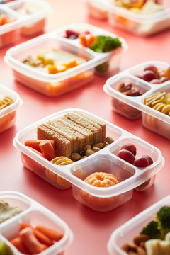 Plastic container with sandwich and fruit.