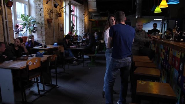 Drunk male pestering defendless woman in bar, grasping hand, pulling. Her boyfriend standing up for female, asking to leave her alone, and neutralizing drunkard applying self defense techniques