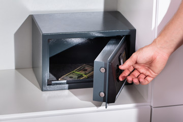 Man's Hand Putting Banknote In Locker