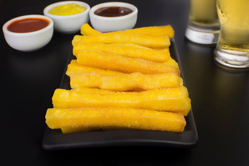 Traditional Brazilian recipe fried polenta in black background