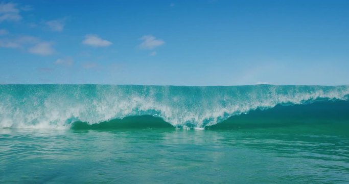 Big wave breaking and crashing with spray in slow motion, amazing ocean shorebreak