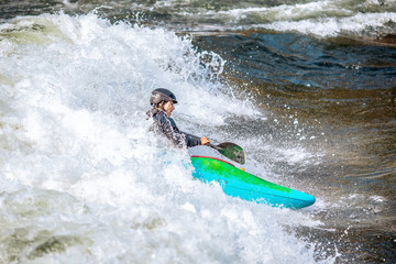 Guy in kayak sails mountain river. Whitewater kayaking, extreme sport rafting