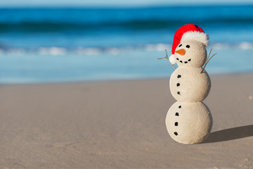 Christmas Sandy Snowman on a beautiful sand beach - Christmas symbol of countries where the weather is always warm