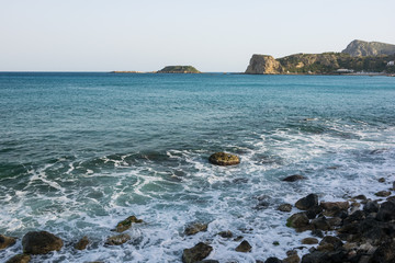 Fototapeta na wymiar Waves On stone beach of the Aegean Sea in Rhodes.