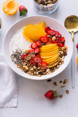 Healthy breakfast. Greek yogurt with fresh apricots, strawberries, walnuts, muesli and honey. Top view
