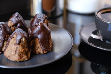 Anthill chocolate cake dessert on a gray plate and cup of coffee . Black table in the kitchen.