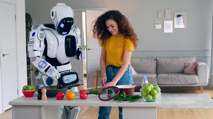 A lady and a robot are cooking and trying food