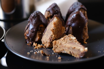 Anthill chocolate cake dessert on a gray plate. Black table in the kitchen.