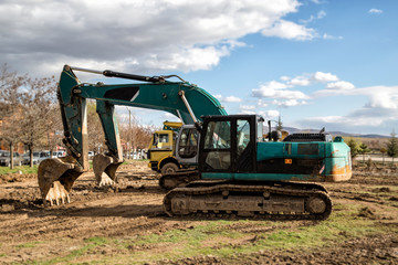 Fototapeta premium Parked excavators and trucks, used construction equipment