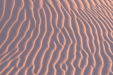 Fototapeta na wymiar Sand texture background. Pink tint.