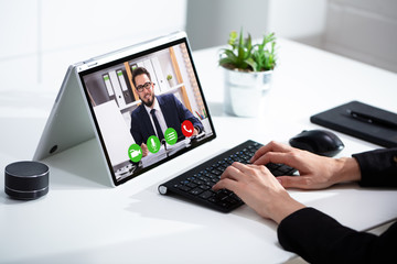 Cropped image of businesswoman using laptop at desk